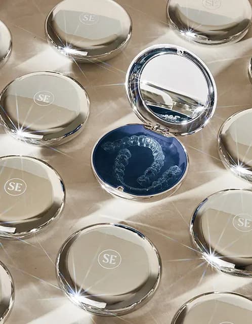 Smile Express aligner cases with one case open and clear aligners inside